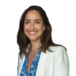 Business-Portr&auml;t von Catherine Niebuhr mit dunklem Haar in wei&szlig;em Blazer und blau gemustertem Kleid vor wei&szlig;em Hintergrund
