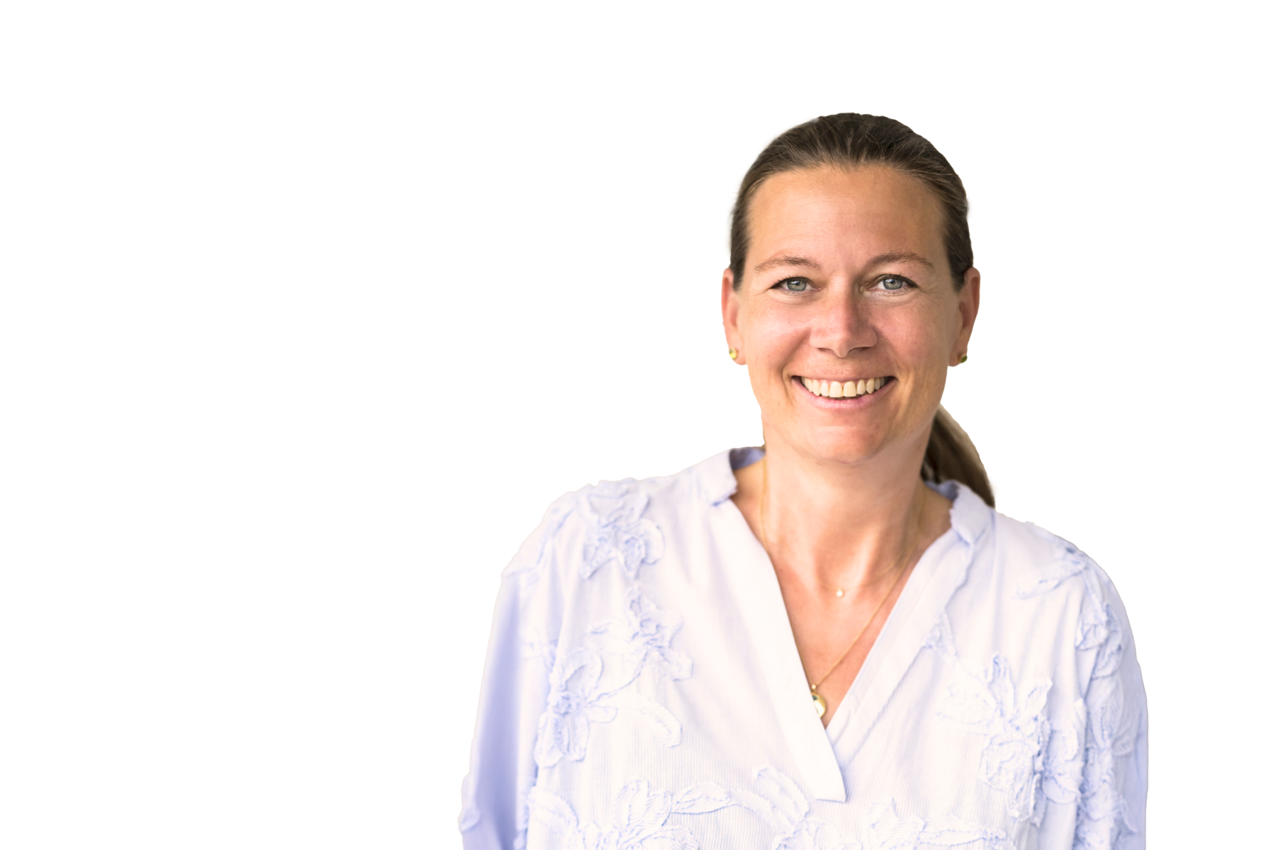 Professionelles Portrait von Astrid Reintjes, Co-Founder & CEO von Miss Pompadour, mit zurückgebundenen braunen Haaren in weißem gemustertem Oberteil vor weißem Hintergrund, strahlend lächelnd in die Kamera blickend. ©Petra Homeier.