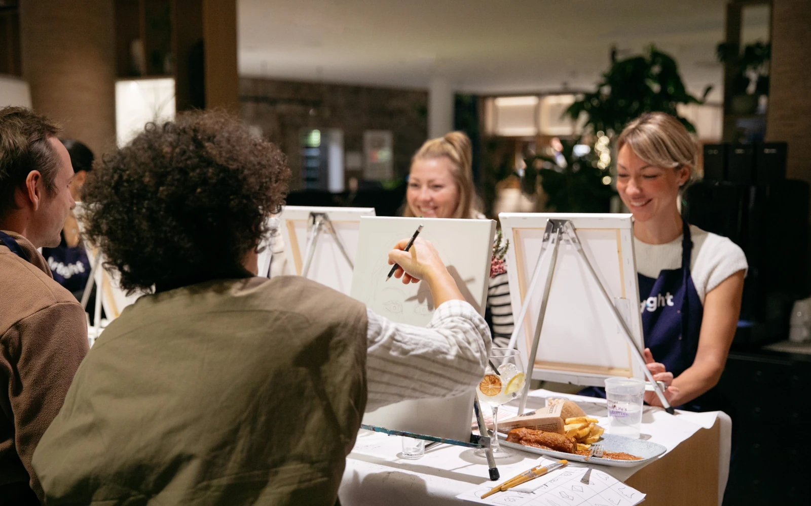 TeilnehmerInnen bei einem ArtNight Malkurs, die fokussiert an ihren Staffeleien malen. Die Szene symbolisiert Konzentration und innere Ruhe im Kontext des "Lead Yourself"-Konzepts.