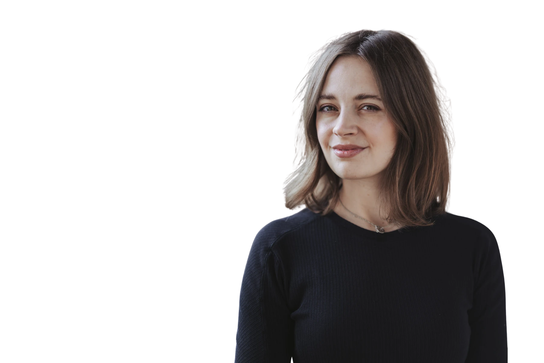 Freigestelltes Porträt von Selina Schröter. Sie trägt ein schwarzes Oberteil, hat schulterlange braune Haare und blickt mit einem sanften, selbstbewussten Lächeln direkt in die Kamera. Der Hintergrund ist komplett weiß.
