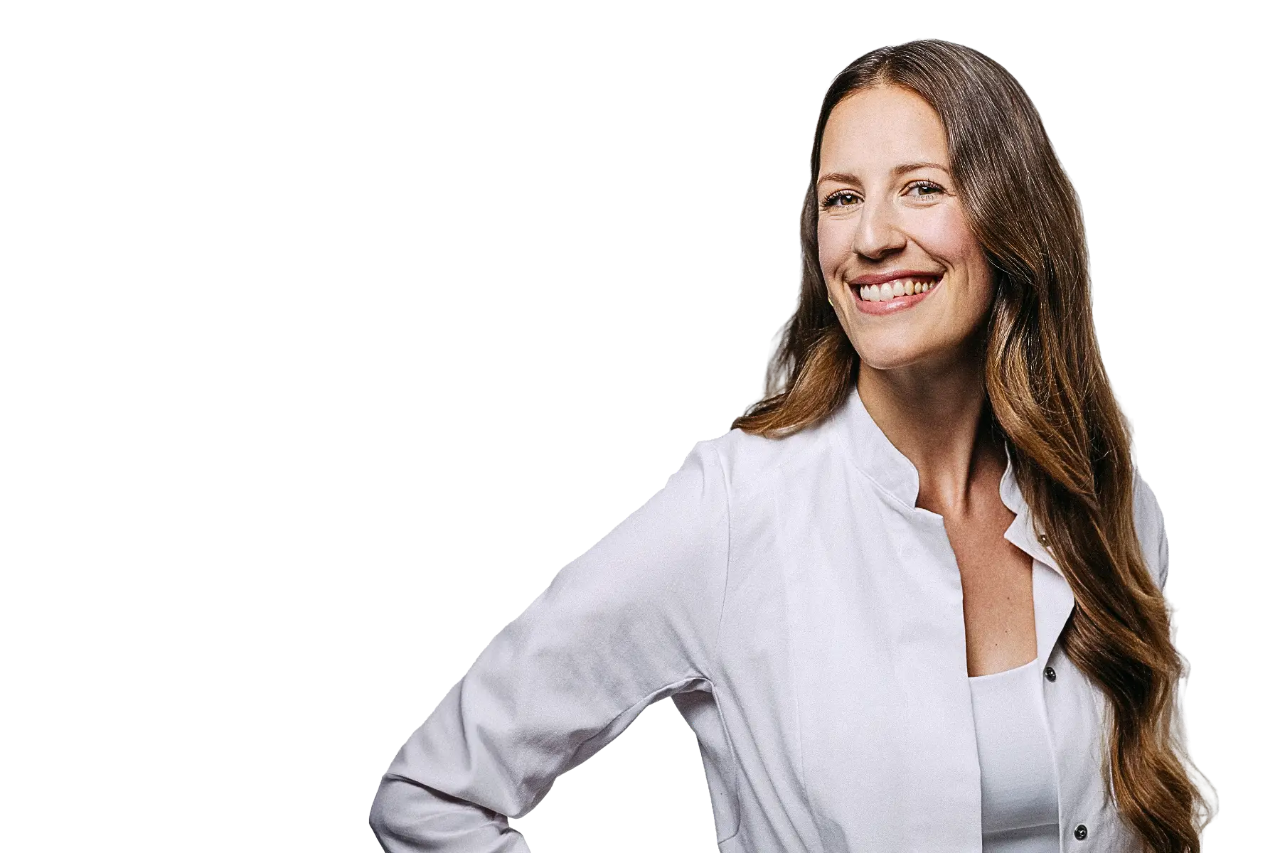 Freigestelltes Porträt von Dr. Anne Latz. Sie trägt einen weißen Arztkittel über einem weißen Top, hat langes gewelltes braunes Haar und blickt lächelnd zur Seite. Der Hintergrund ist komplett weiß.