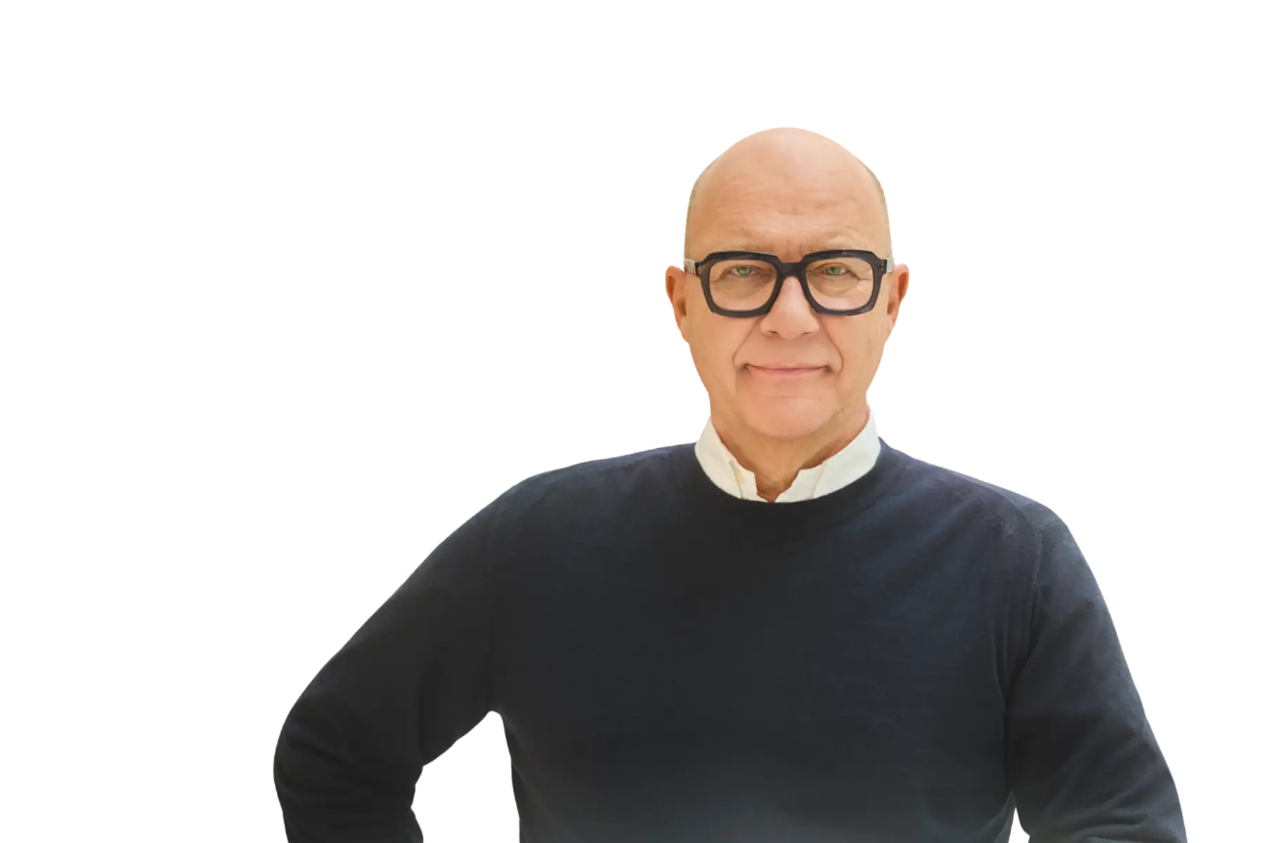 Freigestelltes Porträt von Marc Opelt. Er trägt eine markante schwarze Brille und einen dunkelblauen Pullover über einem weißen Hemdkragen. Er blickt mit einem leichten Lächeln direkt in die Kamera vor einem komplett schwarzen Hintergrund.