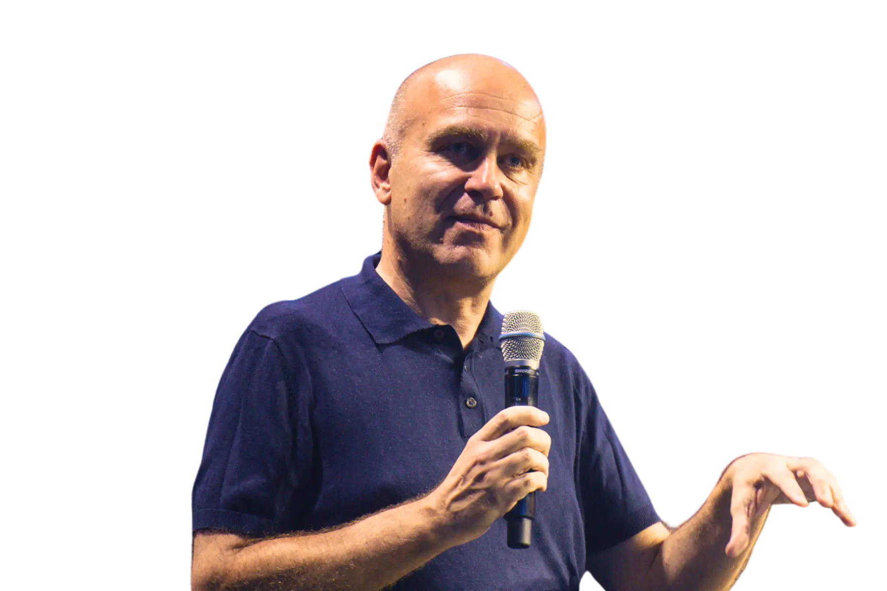 Freigestelltes Porträt von Jochen Krisch, Gründer von Exciting Commerce. Er trägt ein dunkelblaues Poloshirt, hält ein Mikrofon in der rechten Hand und gestikuliert beim Sprechen mit der linken. Der Hintergrund ist komplett weiß.