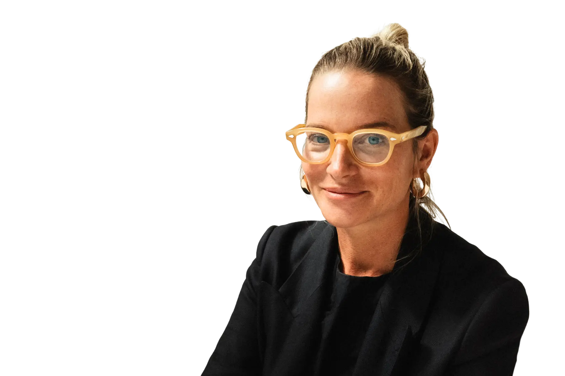 Porträt-Freisteller von Lydia Kind, CMO von Westwing, mit Brille und Dutt, lächelnd in einem schwarzen Blazer vor weißem Hintergrund.