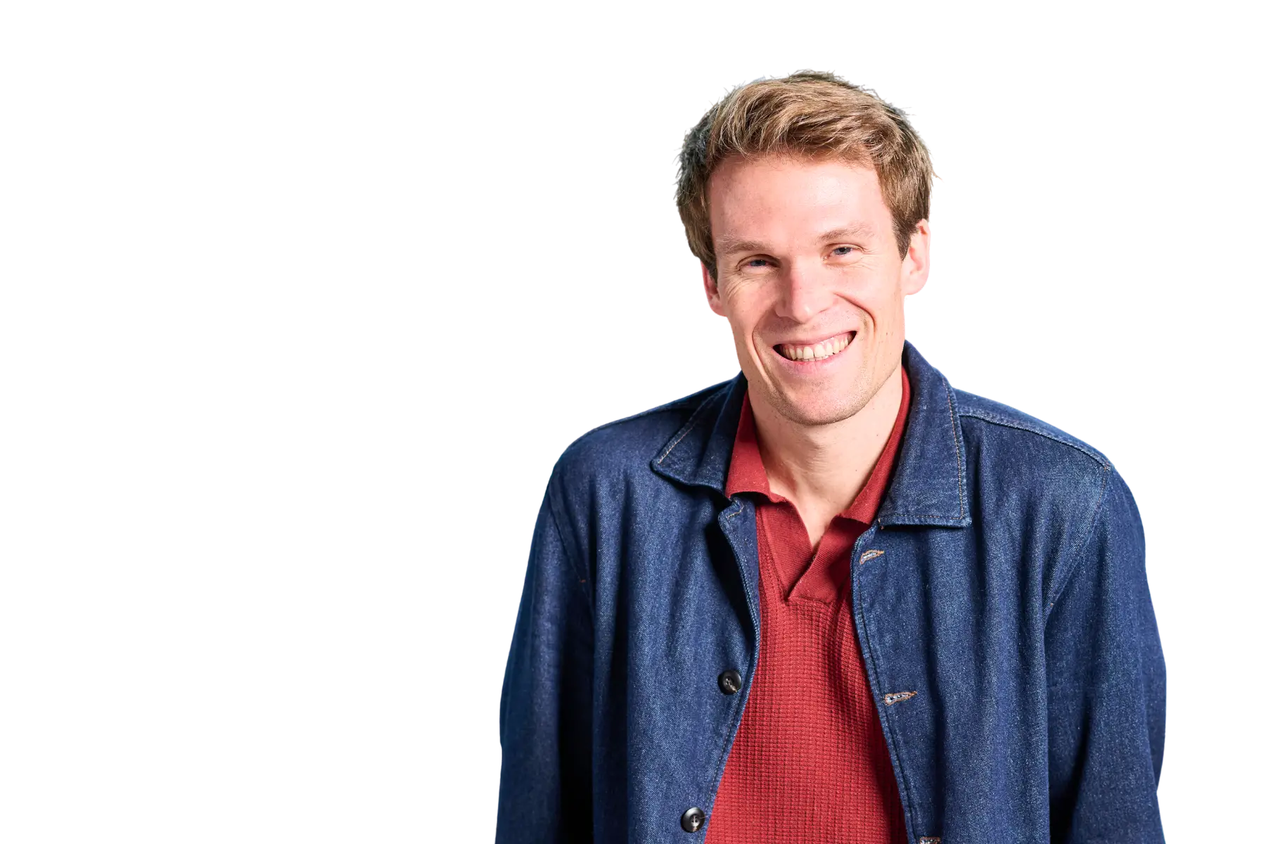 Porträt-Freisteller von Henrik Thiel, VP Sales bei SAP CX, lächelnd in einem roten Poloshirt und einer blauen Jeansjacke vor schwarzem Hintergrund.