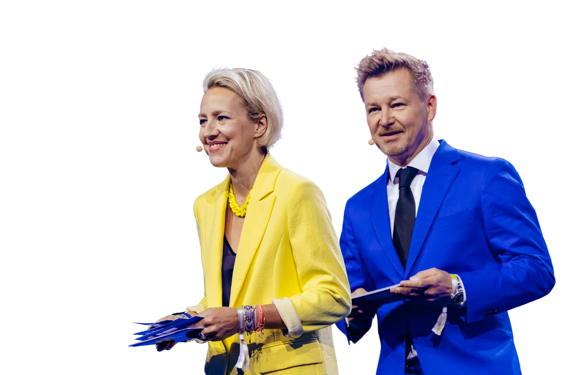 Gemeinsamer Porträt-Freisteller von Verena Schlüpmann im gelben Blazer und Sven Rittau im blauen Anzug mit Moderationskarten vor weißem Hintergrund.